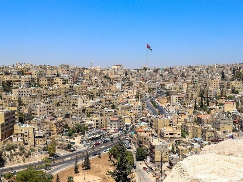 The pale stone rooftops of Amman stacked across its hills