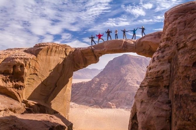 A natural rock bridge spanning a gap high above the desert floor in Wadi Rum